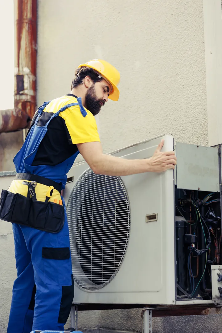 Technik kontroluje venkovní jednotku tepelného čerpadla vzduch–voda
